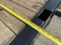 A close-up of a measuring tape extended across the wooden platform of a 2018 Ford F-550 truck bed showing measurements along the wood surface
