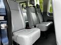 The interior of a 2017 Ford Transit 350 showing gray leather seats arranged in two rows with seat belts visible