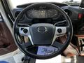 Steering wheel of a 2021 Hino 338 featuring control buttons and a digital display in the dashboard behind it
