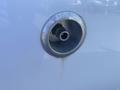 A close-up of a chrome fuel filler neck on a 2017 Ford F-150 with a circular design and a nozzle inside