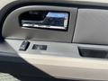 The image shows the interior door panel of a 2013 Ford Expedition featuring a chrome door handle and control buttons for windows and locks