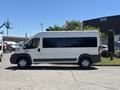 A white 2016 RAM Promaster van is parked in profile showing its large windows and commercial design