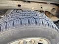 Close-up of a rugged tire mounted on a 2014 GMC Sierra 1500 showcasing deep tread patterns designed for off-road traction