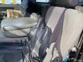 The front driver's seat of a 2009 Dodge Ram 5500 showing wear and tear with a black and gray fabric design