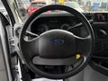 A 2017 Ford Econoline steering wheel with the Ford logo visible in the center and dashboard controls in the background