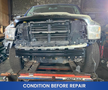 A 2019 RAM 1500 Classic with a partially disassembled front end showing missing parts and damage in a workshop setting
