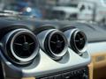 Interior dashboard of a 2005 Ferrari 612 Scaglietti featuring three circular air vents with a silver trim and a black grille