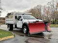 A 2021 Ford F600 truck with a red snow plow attached in the front and a flatbed in the back