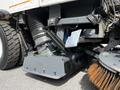 A 2012 Autocar Xpert equipped with a vacuum system and a sweeping attachment showcasing its mechanical components and brushes