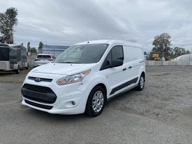 A white 2017 Ford Transit Connect van with a distinctive front grille and alloy wheels parked on gravel ground