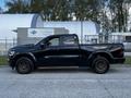 A 2019 RAM 1500 truck in black with custom wheels parked on a street showing its profile and distinctive design