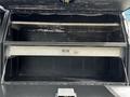 A 2016 Ford F-550 with an open storage compartment featuring metal shelves and a black interior
