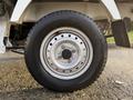 A close-up of a 2008 Suzuki Carry's wheel showing a silver rim and a black tire with visible tread pattern