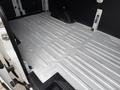 Interior cargo area of a 2022 Ford Transit with a flat, metal floor and walls featuring vertical grooves and a black panel at the back
