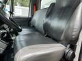 The interior of a 2019 International 4300 featuring two grey leather seats positioned side by side with a steering wheel visible in the foreground