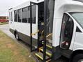 A 2020 Chevrolet Express bus with an open door and yellow steps leading inside