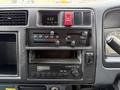 Dashboard of a 2001 Toyota Dyna featuring climate control dials a clock and a radio with volume and tone controls