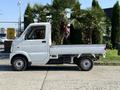2008 Suzuki Carry pickup truck in white with a flatbed design and small wheels visible from the side angle
