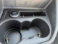 A close-up of the cup holder area in a 2016 Ford Transit with two cup slots and a circular 12V power outlet