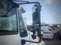 A 2016 International WorkStar 7500 truck featuring a prominent side mirror with a sturdy frame and a clear reflection of the surrounding vehicles