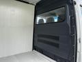 Interior view of a 2012 Mercedes-Benz Sprinter showing the cargo area with a partition wall and window separating the cab from the loading space