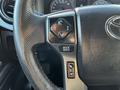 Close-up of the steering wheel controls of a 2021 Toyota Tacoma featuring buttons for audio and driving modes