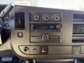 Dashboard of a 2021 Chevrolet Express featuring controls for climate and audio systems along with a digital clock display