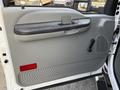 Interior door panel of a 2006 Ford F-550 featuring a handle a speaker grill and a textured bottom section