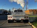 A 2014 RAM 5500 truck with a metallic rear bed and exhaust producing white smoke