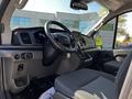 Interior view of a 2023 Ford Transit with a steering wheel and dashboard featuring modern controls and a digital display