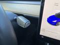 A 2019 Tesla Model 3 gear selector showing positions P R N with a touchscreen display nearby showing a blue car and options for media source