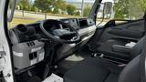 Interior of a 2018 Mitsubishi Fuso FE featuring a steering wheel dashboard and two seats with a modern design and gray upholstery