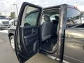 A 2015 RAM 1500 with the driver's door open showing the interior seating and dashboard area