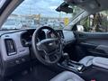 Interior view of a 2018 Chevrolet Colorado showing the steering wheel dashboard and gear shifter in a gray leather finish