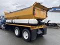 A yellow 2016 International 7400 truck with a large dump bed and white side panels, featuring multiple red reflectors and taillights on the rear