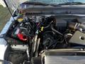 An engine compartment of a 2011 Ford F-350 SD showcasing the engine components including the battery and air intake system