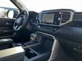 Interior view of a 2023 Toyota Tundra featuring a modern dashboard a touchscreen display and a central console with storage compartments and controls