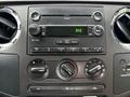Dashboard controls and audio system of a 2008 Ford F-350 with buttons for radio functions and climate control knobs