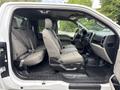 A 2018 Ford F-150 with gray fabric seats and a spacious interior visible from the driver's side door