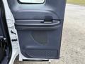 A close-up of the driver's side door panel of a 2001 Ford F-350 featuring a handle speaker grille and textured footrest area