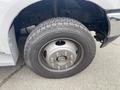 Close-up of a 2003 Ford F-450 SD tire and wheel with visible lug nuts and treads