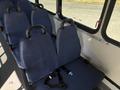 Interior view of a 2017 Chevrolet Express showing several blue fabric seats with safety straps attached