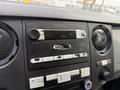 Interior dashboard of a 2013 Ford F-550 featuring a radio and various controls with some wear visible on the buttons and knobs