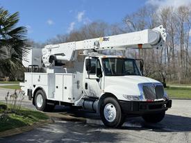A 2011 International 4300 bucket truck with a white body and extended aerial work platform on top