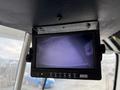 Monitor displaying a dark screen mounted on the interior ceiling of a 2010 Autocar Xpeditor with control buttons below