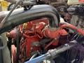 Detailed view of the engine of a 2022 International MV607 with red and black components and various hoses connected throughout the assembly