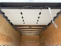 A 2022 Ford E-450 van with an open, empty cargo area featuring wooden panels and a metal roof structure