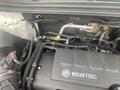 Close-up of the engine compartment of a 2018 Buick Encore showing various components and the ECO TEC engine cover