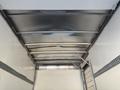 Interior view of a 2013 Isuzu NPR box truck showing metal ceiling beams and a white insulated inner surface