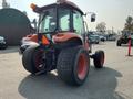 A red 2014 Kubota tractor with large rear tires and a cab, viewed from the back, showcasing its agricultural design